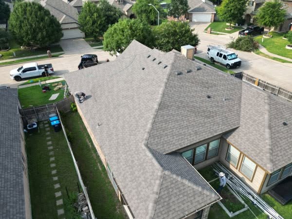 Aerial view of a completed shingle roof installation in a Weatherford, TX neighborhood