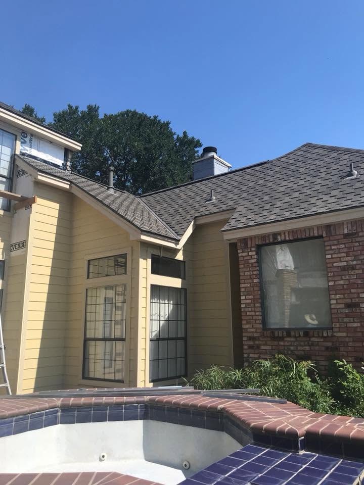 Completed roof and siding on a multi-family building beside the pool deck