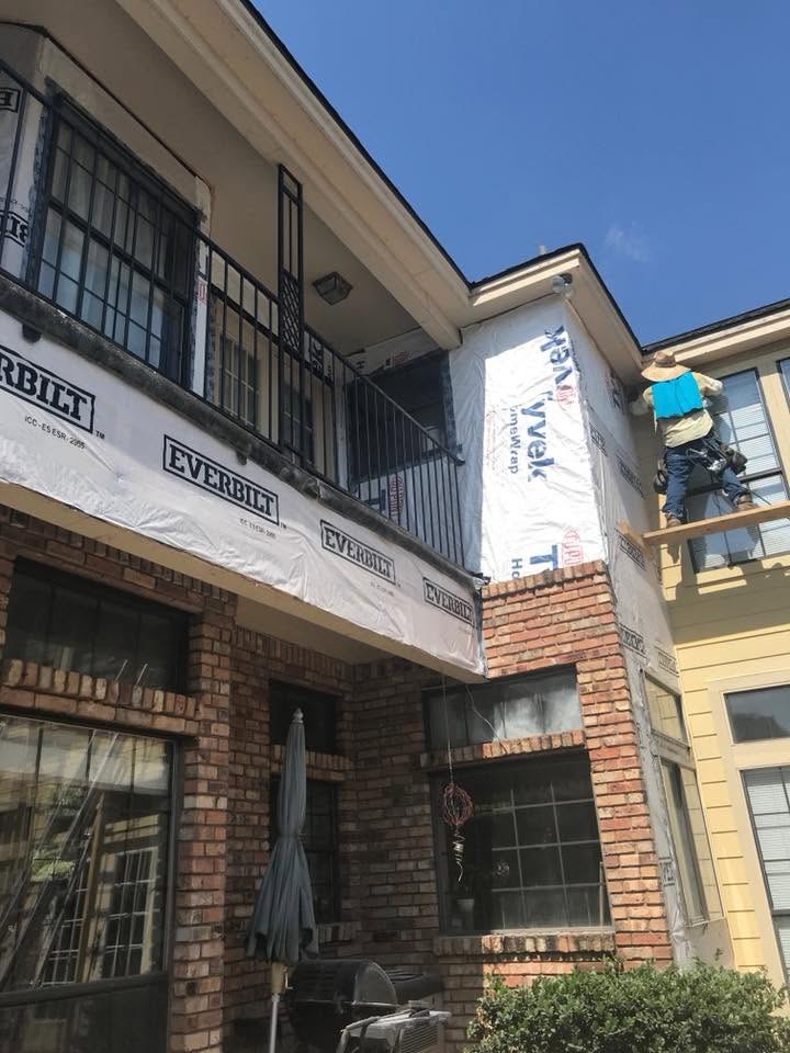 House wrap being installed across balconies on a multi-family exterior renovation
