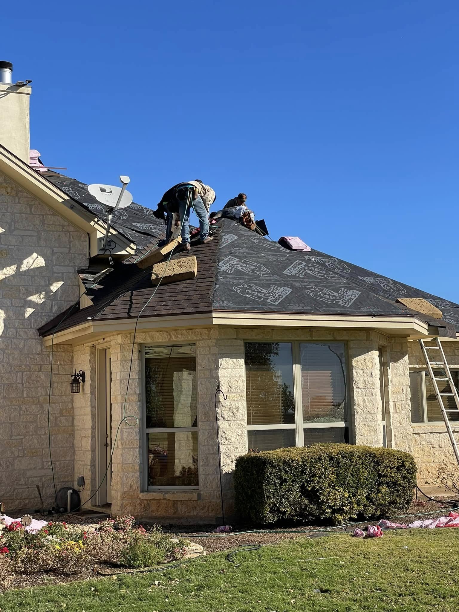 Mid Cities Roofing crew working on a roof replacement with debris being cleared as they go